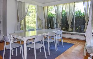 a dining room table with white chairs and a window at Beautiful Home In Flyinge in Flyinge