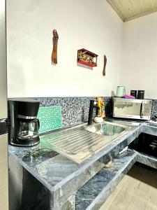 eine Küche mit einer Arbeitsplatte und einem Tisch in der Unterkunft En-suite Paraiso #1 in Parrita