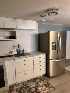 a kitchen with white cabinets and a stainless steel refrigerator at Suhira Hospitality in Lansdowne +11 photos