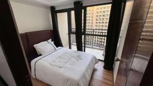 a bedroom with a bed with a view of a building at Bayport West Naia Residences in Manila