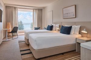 克罗纳拉Rydges Cronulla Beachside的酒店房间里有两张床，窗户很大 更多34张照片