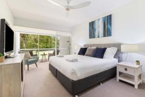 Un dormitorio con una cama grande y una sala de estar. en Mirage Resort Villa 130 with access to Sheraton Facilities, en Port Douglas