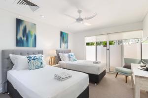 1 dormitorio con 2 camas, sofá y escritorio en Mirage Resort Villa 130 with access to Sheraton Facilities, en Port Douglas