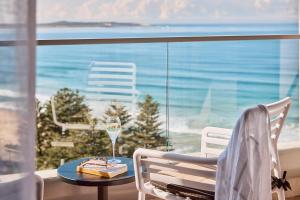克罗纳拉Rydges Cronulla Beachside的一间设有一张桌子和一杯葡萄酒的房间