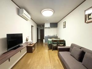 大阪天下茶屋 三好吉房的带沙发、电视和桌子的客厅