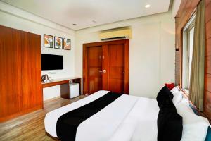 a bedroom with a large bed and a television at Hotel O Airport Road in Ahmedabad +16 photos
