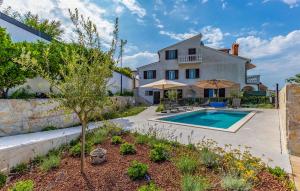 a villa with a swimming pool in front of a house at 1 Bedroom Stunning Apartment In Medulin in Medulin