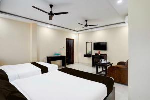 a hotel room with two beds and a tv at Hotel O Tirumala Road Near Alipiri in Tirupati +23 photos