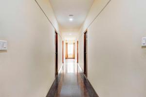 an empty corridor with white walls and a long hallway at Hotel O Tirumala Road Near Alipiri in Tirupati