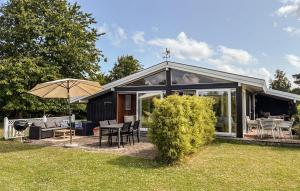 a small house with a patio and an umbrella at Gorgeous Home In Gilleleje With Wifi in Gilleleje +6 photos