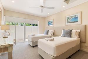 a bedroom with two beds and a couch at Mirage Resort Villa 136 with access to Sheraton Facilities in Port Douglas