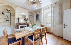 a dining room with a table and chairs and a chandelier at Maison Avec Jardin in Sens +31 photos