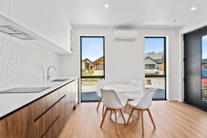 cocina con mesa blanca, sillas y ventanas en Stylish 1BR Escape Near Remarks, en Queenstown Airport