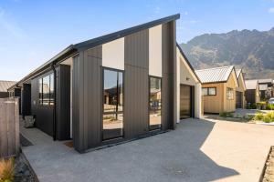 Una casa con grandes puertas de vidrio en un camino de entrada. en Stylish 1BR Escape Near Remarks, en Queenstown Airport