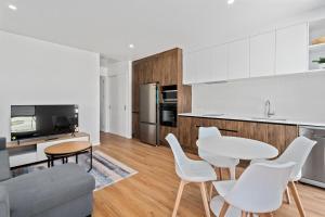 Una cocina y una sala de estar con mesa y sillas. en Stylish 1BR Escape Near Remarks, en Queenstown Airport