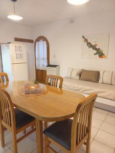 a dining room with a table and chairs and a couch at Departamento Mamá Inés in Esquel