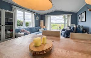a living room with a dining room table with yellow candles at 2 Bedroom Nice Home In Lauwersoog in Lauwersoog