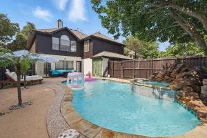 a swimming pool in front of a house at The Beach Oasis In Dallas, Pool & Sauna in Plano