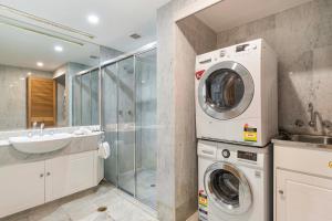 Un baño con lavadora y lavabo. en Mirage Resort Villa 144 with access to Sheraton Facilities, en Port Douglas