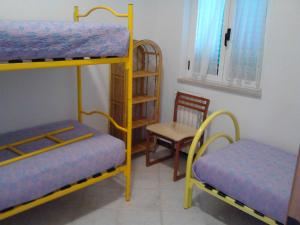 ジノーザ・マリーナにあるVilla Annaの二段ベッド2台と椅子が備わる客室です。