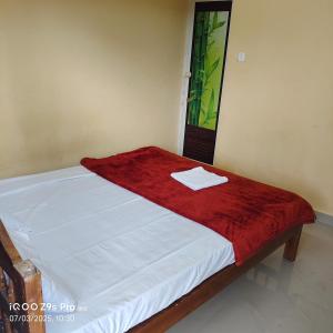 a bed in a room with a red blanket on it at Anaswaramholidays in Jāmb
