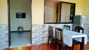 a dining room with a table and chairs and a television at Tropical Garden Apartment in Moalboal