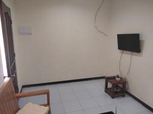 a living room with a tv on a white wall at Tropical Garden Apartment in Moalboal