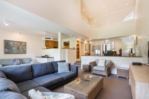 una sala de estar con un sofá y una mesa en Mirage Resort Villa 146 with access to Sheraton Facilities, en Port Douglas