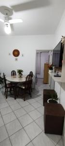 Una sala de estar con mesa y sillas y una cocina. en Condomínio edifício cannes, en Praia Grande
