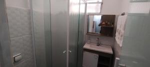 Un baño con ducha, lavabo y espejo. en Condomínio edifício cannes, en Praia Grande 12 fotos más