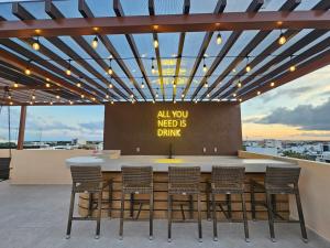 a bar with chairs and a sign that reads all you need is drink at 1BR Comfort and style, near 5th Avenue with Pool in Playa del Carmen