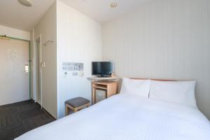 盛冈Washington R&B Hotel Morioka Ekimae的卧室里有一张白色的床和一台电视 更多9张照片