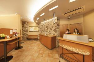 盛冈Washington R&B Hotel Morioka Ekimae的大厅里有两个人坐在柜台旁