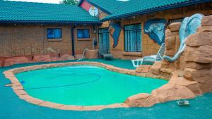 a swimming pool in front of a house with a painting at Sikhula Sonke Guest House in Bronkhorstspruit