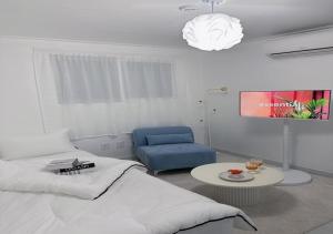 a bedroom with a bed and a blue chair at 정담 신도림역 투룸 무료주차 in Seoul