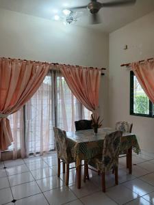 a dining room with a table and chairs and windows at Garden's Guest House, Semenyih in Beranang