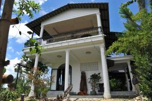 une maison avec un balcon au-dessus dans l'établissement Homestay Villa White House, 