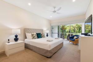 Un dormitorio blanco con una cama y una ventana. en Mirage Resort Villa 152 with access to Sheraton Facilities, en Port Douglas
