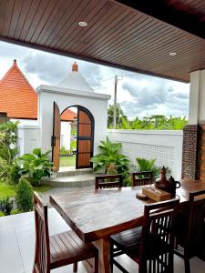 a dining room with a wooden table and chairs at Lebak Agung Guest House in Canggu