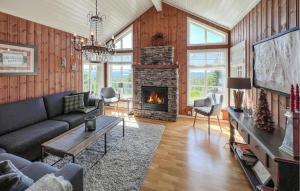 a living room with a couch and a fireplace at Gorgeous Home In Sjusjøen With Sauna in Sjusjøen