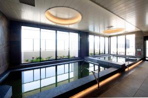 a swimming pool in a building with windows at THE RISE Osaka Universal Bayside in Osaka