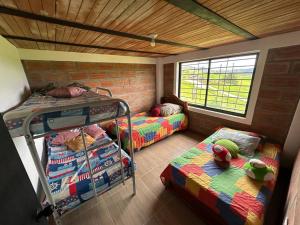a room with two bunk beds and a window at Casa de Campo en San Pedro in San Pedro