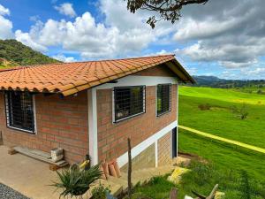 a small brick house with a green field behind it at Casa de Campo en San Pedro in San Pedro