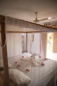a bed with pink flowers on it in a bedroom at Finca Montaña Sagrada in Mérida