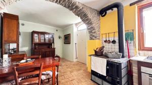 a kitchen with a table and a stove at The quiet yellow house in Pornassio