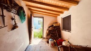 The quiet yellow house في Pornassio: ممر منزل به كومة من الخشب