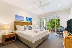 a bedroom with a bed and a living room at Mirage Resort Villa 179 with access to Sheraton Facilities in Port Douglas