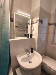 a white bathroom with a sink and a toilet at Ferienapartment am Dorfteich in Trebbin +12 photos