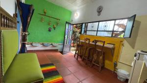 a room with a green wall and a bar with stools at Refugio tornasol in Duitama