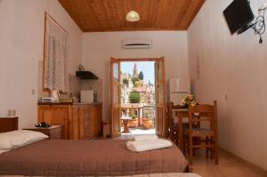 a bedroom with two beds and a kitchen with a balcony at Athina Studios in Symi